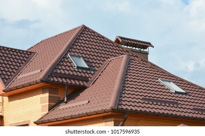 Metal roof with modern house attic construction with roof guttering and attic skylight. window.  Attic skylights. Roofing construction problem area.