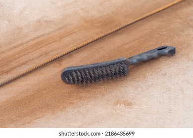 A Metal Rust Cleaning Brush Lies Next To A Rusty Metal Rod