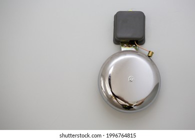  Metal school bell over grey wall - Shutterstock ID 1996764815