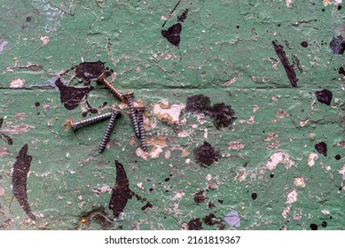 Metal Screws On An Old Painted Exfoliating Wooden Table. Flatlay And Coppy Space.