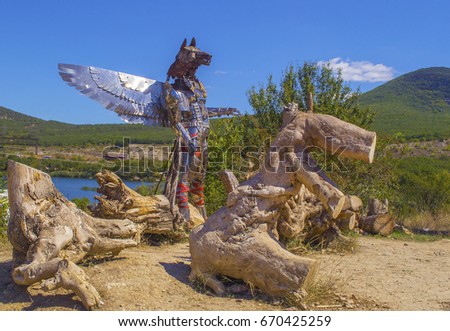 Metal sculpture of winged knight-wolf made of details of old cars. Camp of bikers. Russia