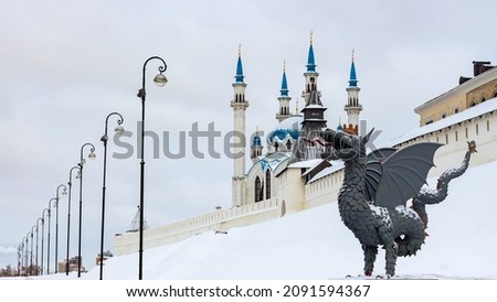 Metal sculpture of Zilant, the official symbol of Kazan. Winter view at the Kazan Kremlin wall and Kul Sharif mosque. Tatarstan, Russia