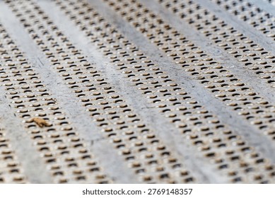 A metal sheet featuring multiple rows of small rounded holes arranged in a repetitive pattern, showcasing industrial texture and design.