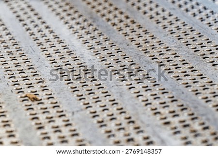 A metal sheet featuring multiple rows of small rounded holes arranged in a repetitive pattern, showcasing industrial texture and design.