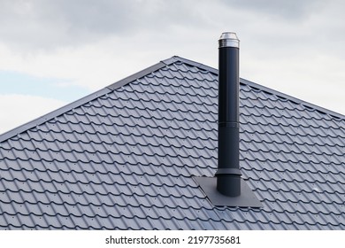 Metal sheet roof and metal chimney on the roof of the house.