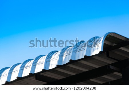 Metal sheet roof curve on blue sky,Modern construction. Metal ribbed arch-span roof covering