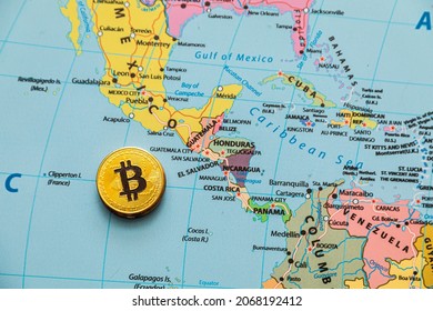 metal shiny bitcoin crypto currency coins on a map of the world. El Salvadore. bitcoin legalization. Electronic decentralized money concept.