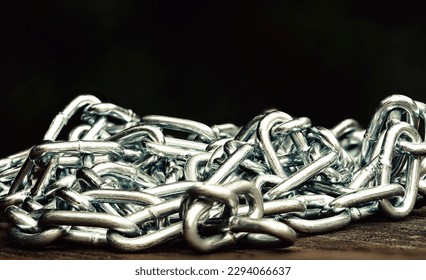 Metal shiny chain on a wooden surface close-up