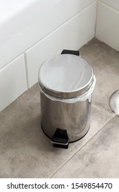 Metal Silver Garbage Can With Lid On The Floor In The Hotel Bathroom With White Tiles  On The Wall. Bathroom Modern Luxury Interior 