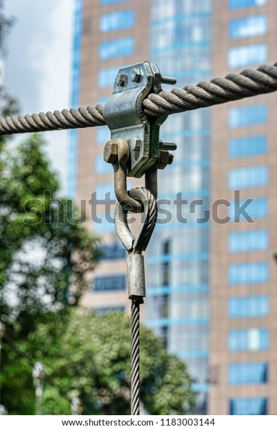 Metal sling cable and nut of hang bridge with\
selected focus and blurry\
background