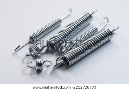 Metal springs on a white background. Manufacture of springs of different sizes.