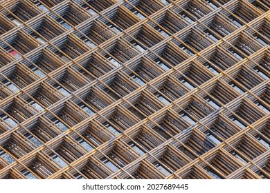 Metal square grid pattern formed by twisted steel interwoven rods or bars. Abstract background of square shapes and right angles forming diagonal lines - Shutterstock ID 2027689445