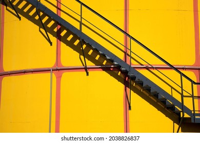 Metal Staircase On A Yellow Fuel Storage Tank With Shadow