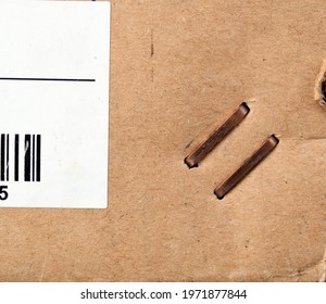 Metal Staples On The Corner Of A Cardboard Box.Box Staplers Ensure Fast And Secure Lid Closing.A Closeup Of A Brown Cardboard Box.