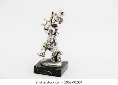 Metal Statue Of A Bagpipe Player On A White Background