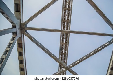 Metal and steel bars, beams and structures of the bridge against blue sky