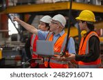 Metal steel sheets factory manager and employees inspecting products inside factory. Metalwork manufacturing Team professional walking training work for employees. Check quality of work with laptop.