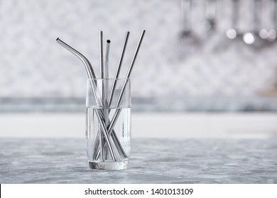 Metal Straws In Transparent Glass Of Water On Kitchen Worktop