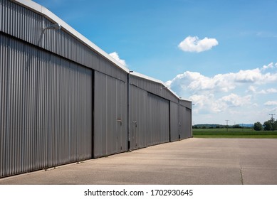 Metal Structure Hangar From A Private Airport In Germany. Hangar Exterior View On A Beautiful Summer Day. Private Airport Hangar.