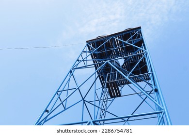 Metal structure water tank tower  Detail steel structure supporting blue plastic water storage tank in bottom view bright blue sky background and copy space   selective focus 