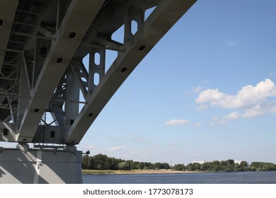 Metal structures of the bridge, river, beach, blue sky