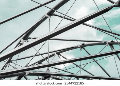 Metal structures with mesh and cables under a blue sky, forming an abstract modern architectural design - Powered by Shutterstock