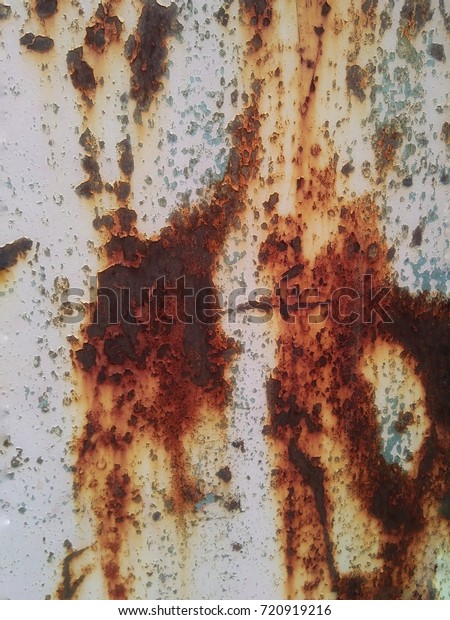 The metal surface rusted .Rust stains.Corroded
metal background. Rusted  painted metal wall. Rusty metal
background with streaks of
rust.