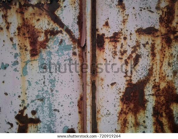 The metal surface rusted .Rust stains.Corroded\
metal background. Rusted  painted metal wall. Rusty metal\
background with streaks of\
rust.
