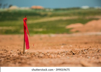 Metal Survey Peg With Red Flag On Construction Site.