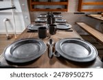 metal tableware for sailors and passengers on the table the lower deck on an old sailing ship