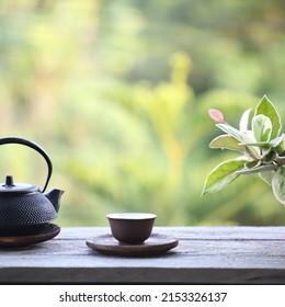 Metal Tea Pot And Tea Cup And Plant Pot On Wooden Table