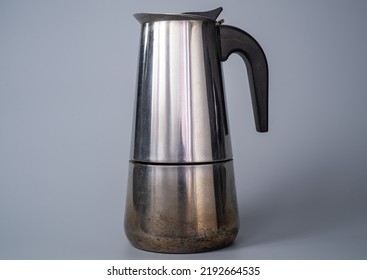 Metal Teapot, Cezve For Brewing Coffee On A Gray Studio Background. Coffee Maker For Brewing Ground Coffee With Water On Gas. Chrome Shiny Coffee Maker For Your Morning Drink For Breakfast.