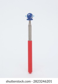 Metal telescopic pointer tool with red handle and astronaut helmet top on white background
