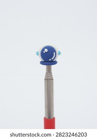Metal telescopic pointer tool with red handle and astronaut helmet top on white background