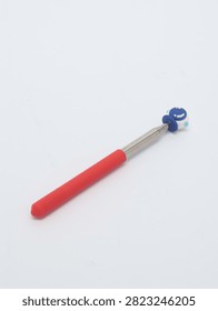Metal telescopic pointer tool with red handle and astronaut helmet top on white background