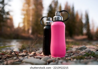 metal thermo bottle on pebble beach of river  - Shutterstock ID 2213922215