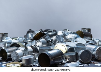 Metal tins, cans and jar garbage from household on the table. City home trash made of aluminum. Empty used, food and drink steel packaging waste and scrap discarded sorted and ready to recycle. 