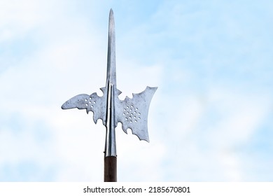 Metal Top Of A Halberd, Also Called Halbard, Halbert Or Swiss Voulge, With Axe Blade And Spike Against A Cloudy Blue Sky, Pole Weapon, Copy Space, Selected Focus