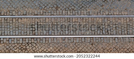 Metal tram rails on the cobblestone pavement. View from above