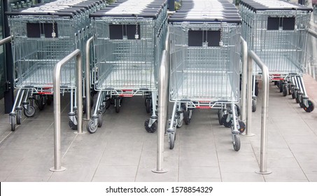 Metal trolleys at supermarket entrance. Cart for food and things as user's urge to consummation - in truck gaining more goods than in basket. Small secrets in Commerce for which hide big money concept - Shutterstock ID 1578854329