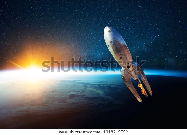Metal\
vintage rocket with fire takes off into open starry space near the\
planet earth with sunset. Retro spacecraft lift off and flies on a\
background of the starry sky, planet and\
sunlight