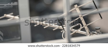 Metal vintage tv antenna mounted on building rooftop outdoor. Television old antenna for tv and radio signal reception.