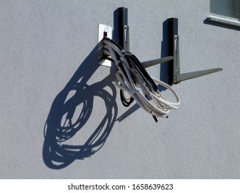 Metal Wall Bracket Detail. Air Conditioning Unit Adjustable Support Bolted To Stucco Finished Exterior Wall. Coiled Electrical Cable Provision For Future Connection. Home Cooling System Concept