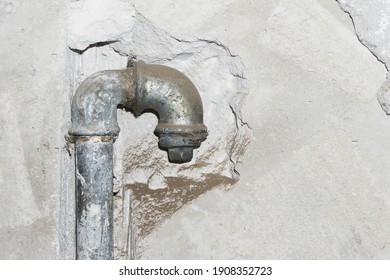 Metal water pipe. Old house plumbing system background. Grunge rusty steel pipe. Iron piping in the wall. Plumber background. Empty copy space pipe. Closeup pipeline. Bathroom renovation background.
