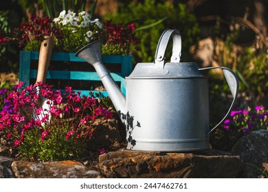  Metal watering can in the garden of flowers - Powered by Shutterstock