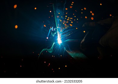 Metal welding. Fire from operation of welding machine. Manufacture of steel seam. Processing of steel profile. Sparks from welding. Smash in dark in workshop.