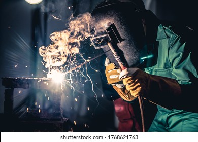Metal welding steel works using electric arc welding machine to weld steel at factory. Metalwork manufacturing and construction maintenance service by manual skill labor concept. - Shutterstock ID 1768621763