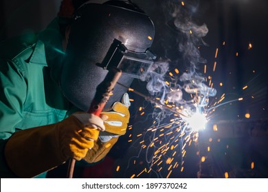 Metal welding steel works using electric arc welding machine to weld steel at factory. Metalwork manufacturing and construction maintenance service by manual skill labor concept.