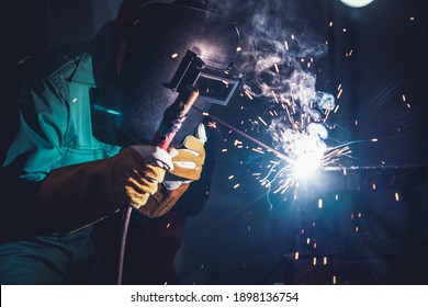 Metal welding steel works using electric arc welding machine to weld steel at factory. Metalwork manufacturing and construction maintenance service by manual skill labor concept. - Shutterstock ID 1898136754