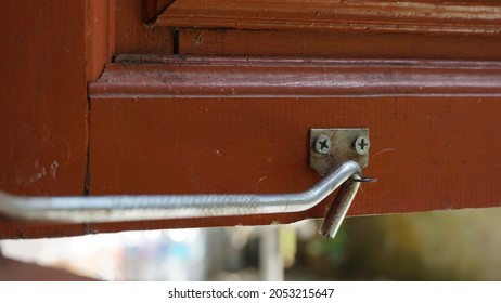 A Metal Window Hook Placed On Windowsill. A Steel Window Lock Hook Placed To Keep The Window Open